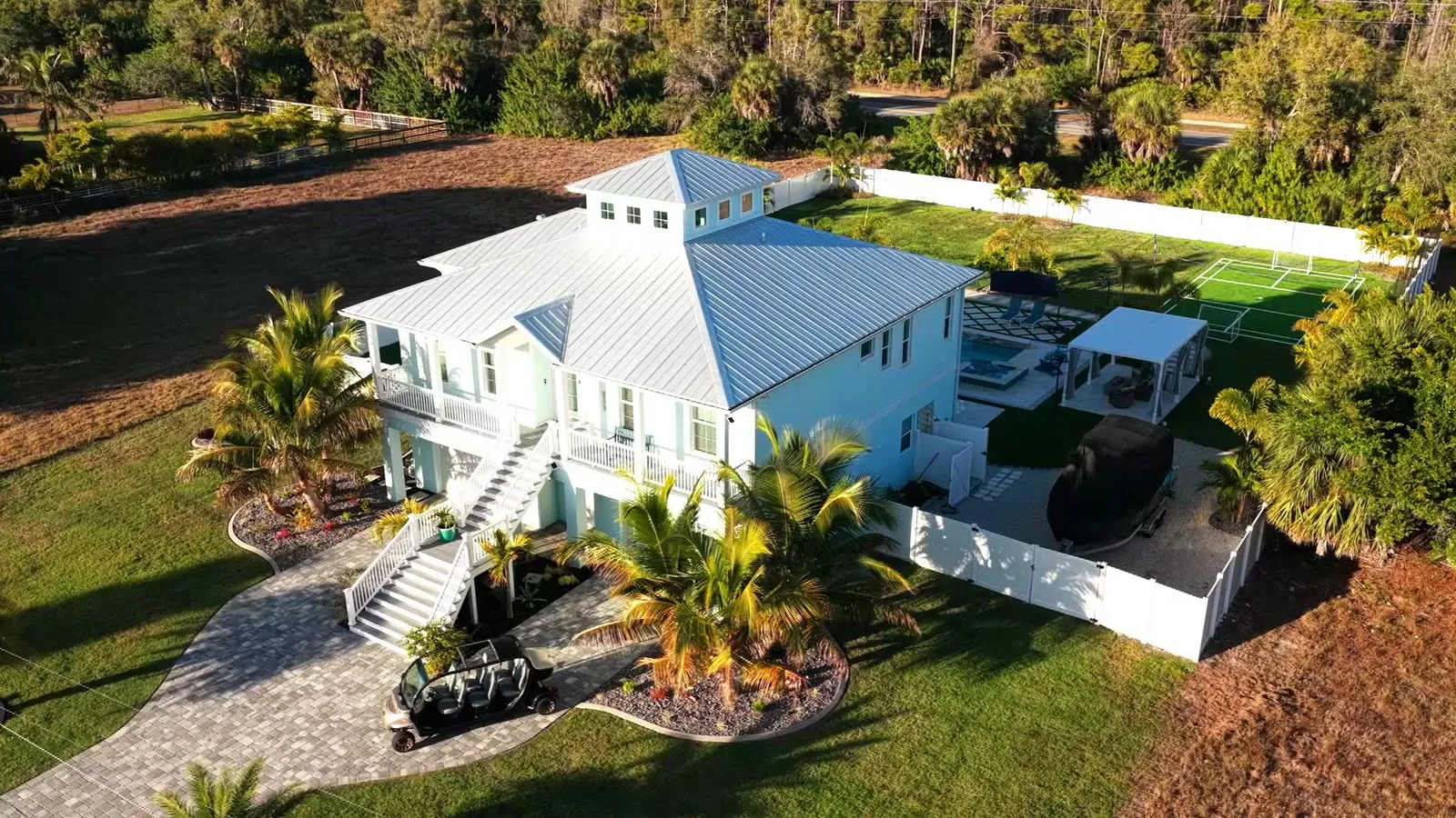 Aerial view of Seaside Boca — the resort-style pool, private mini golf, and turf court seen from above