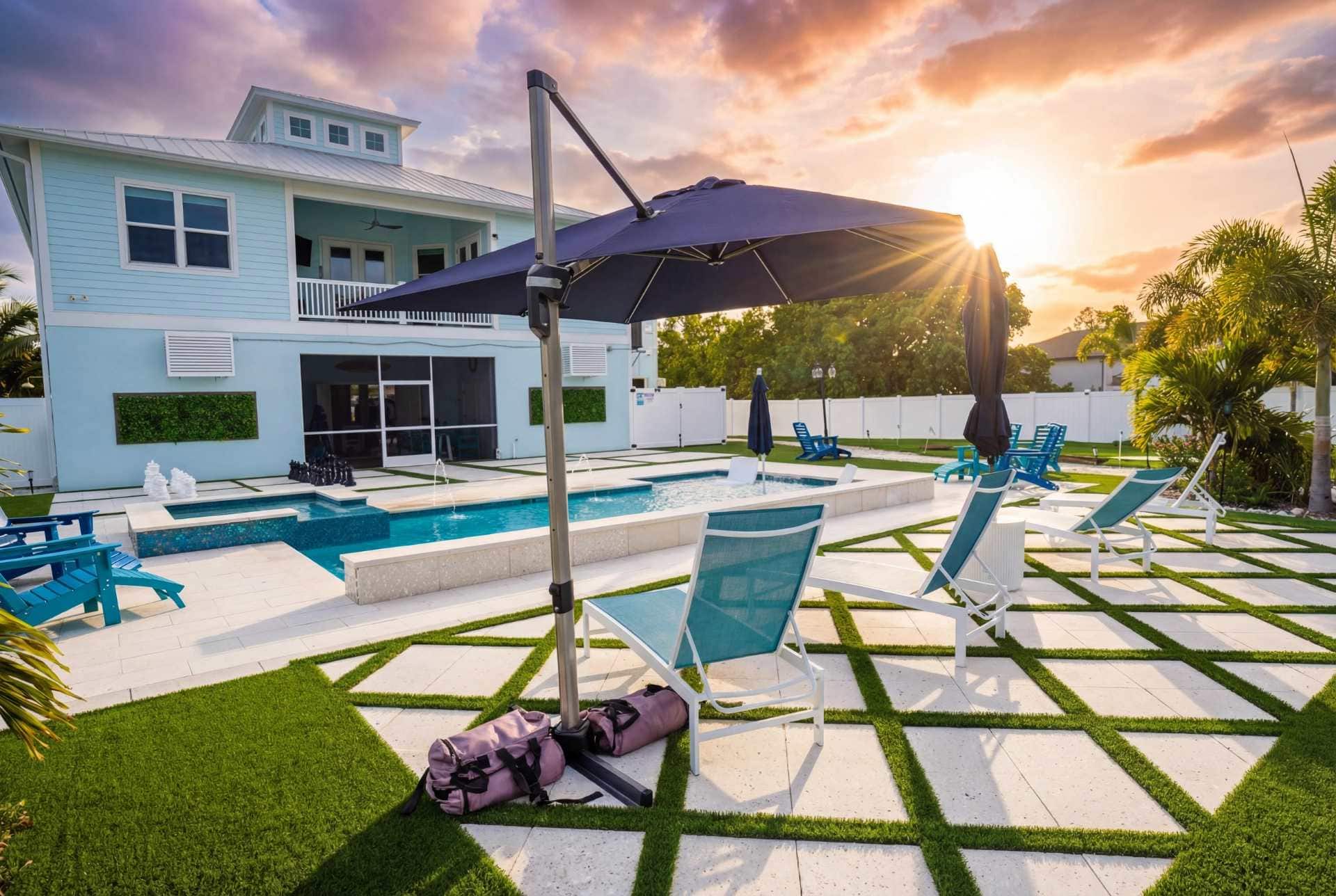 Backyard pool deck with teal loungers and umbrella at golden hour