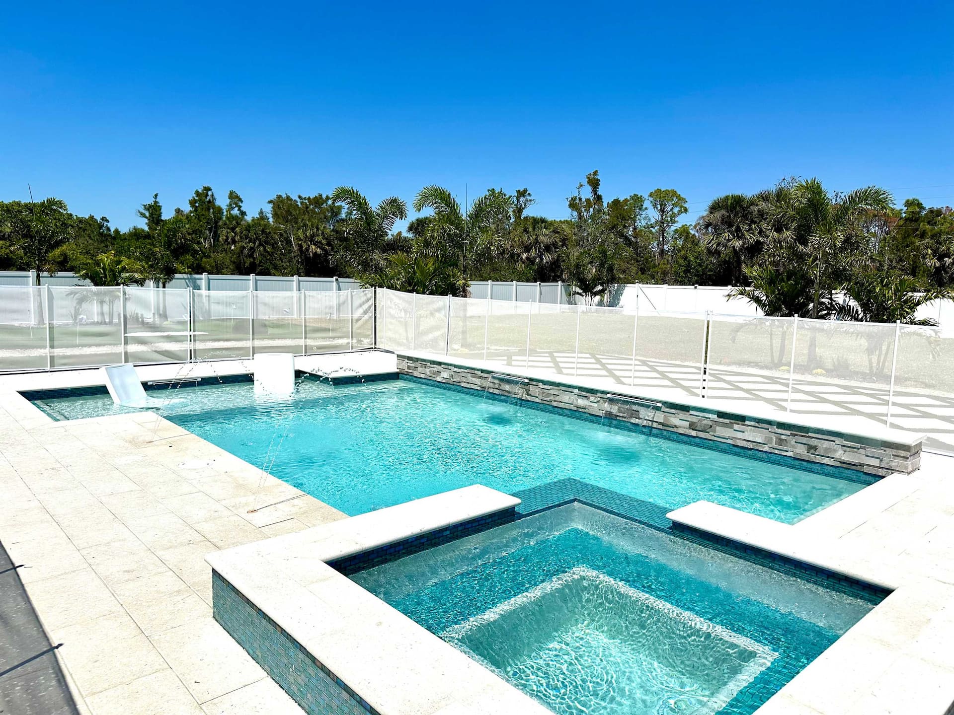 Tiled pool and attached hot tub on the paver sun deck