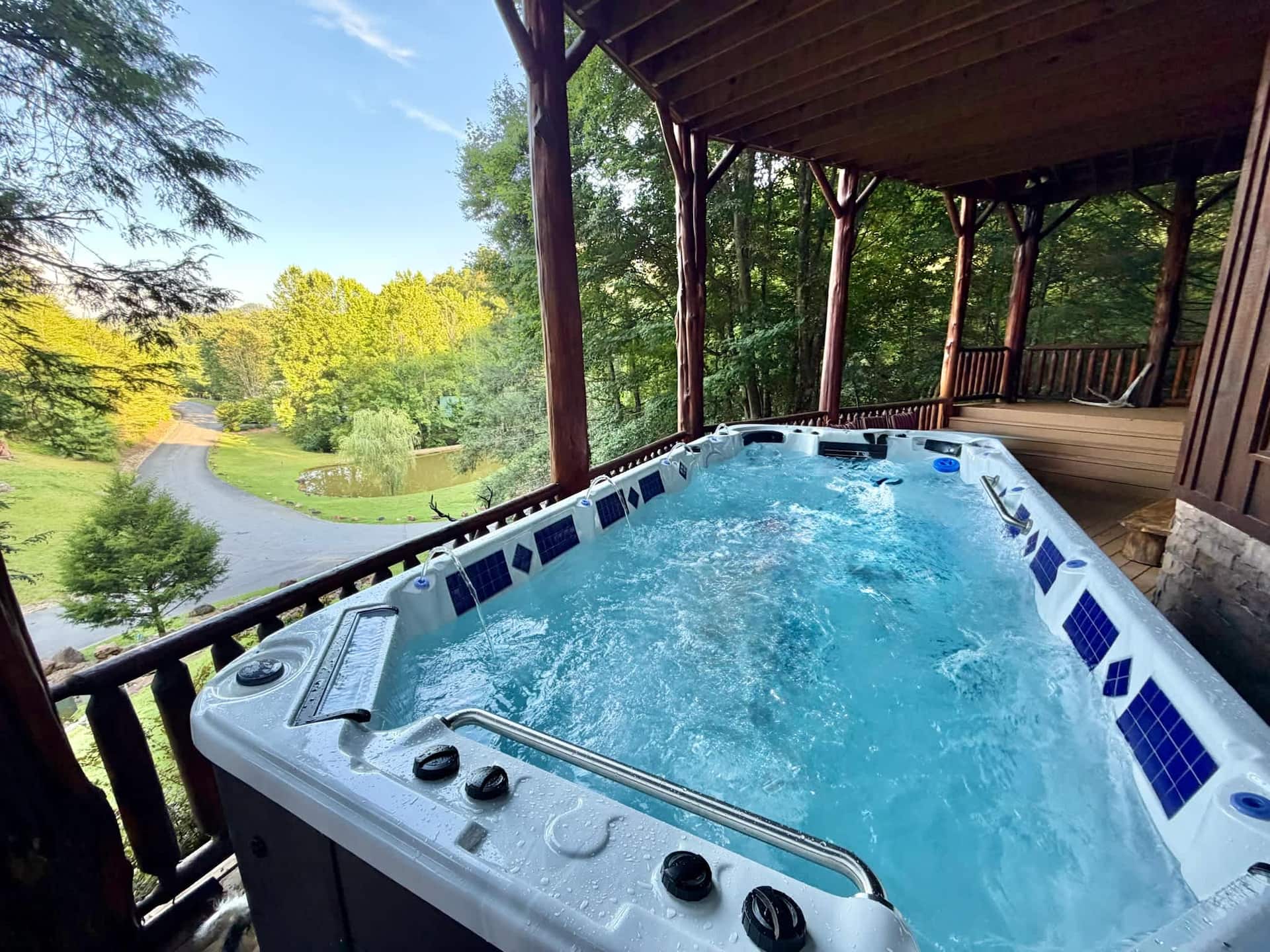Swim spa on the covered deck, jets running, looking out over the pond and resort drive